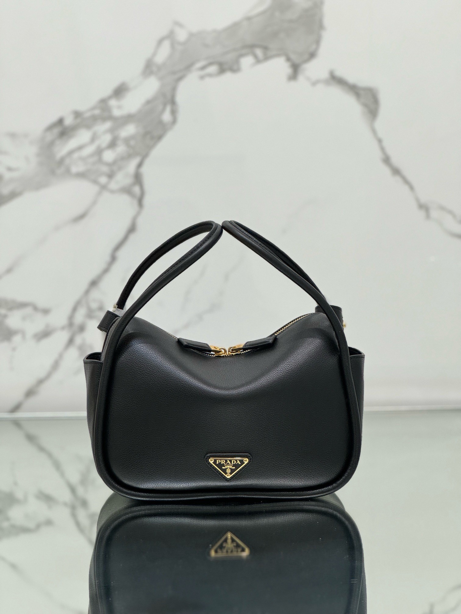 Pra*a top handle bag in black grained leather