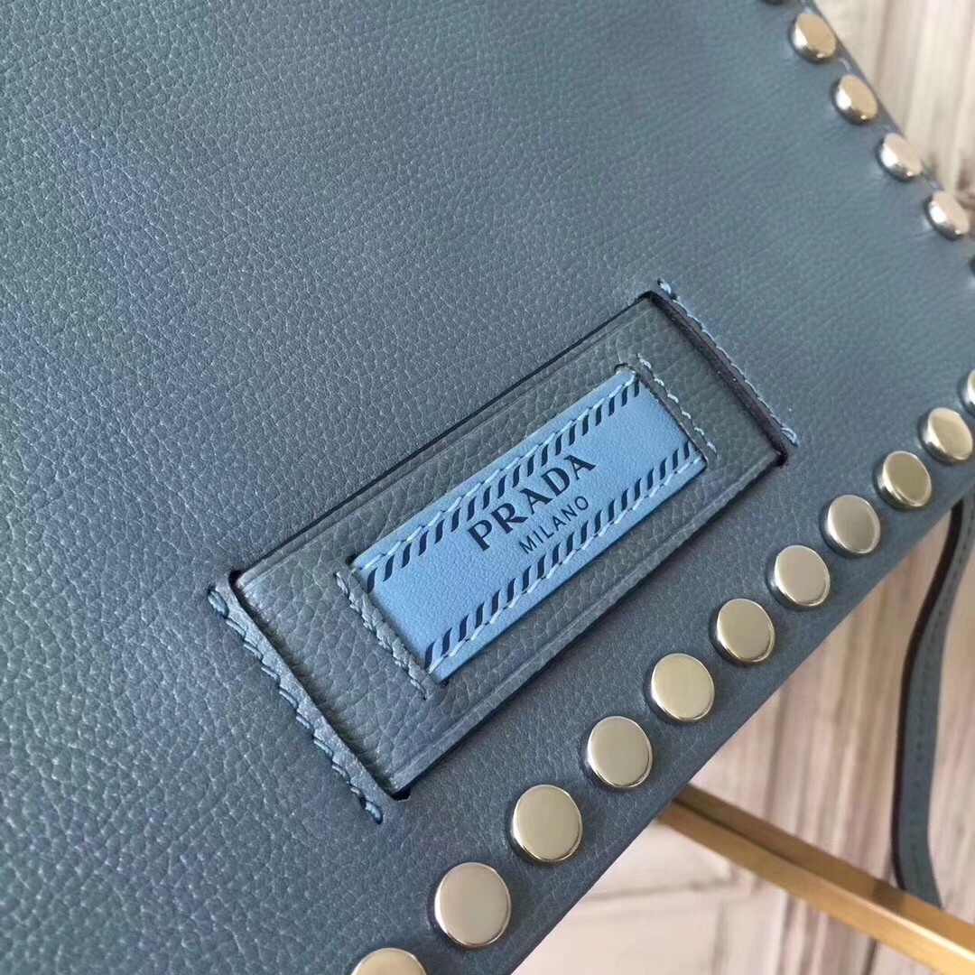 Pra*a etiquette bag in blue calfskin with metal stud trim