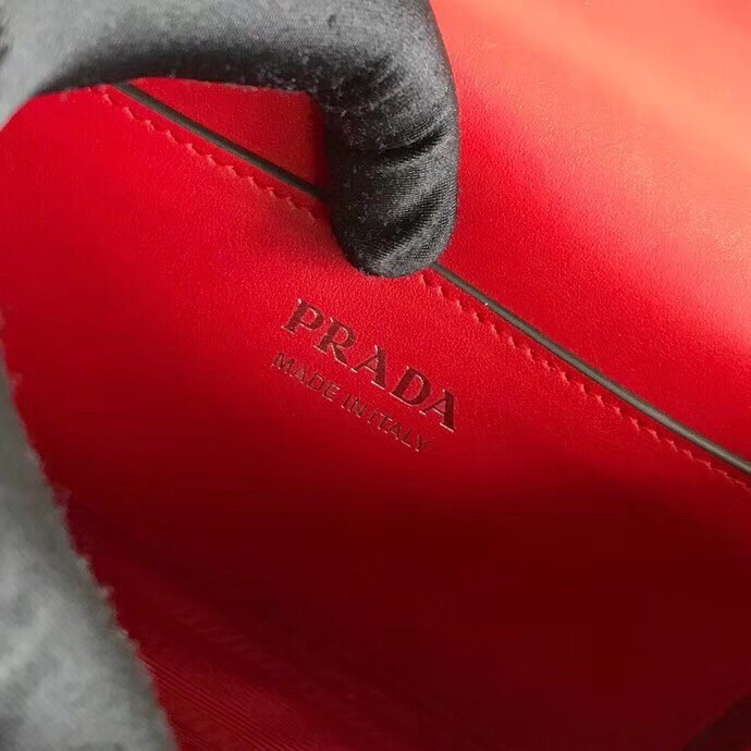 Pra*a red monochrome flap bag with metal appliques