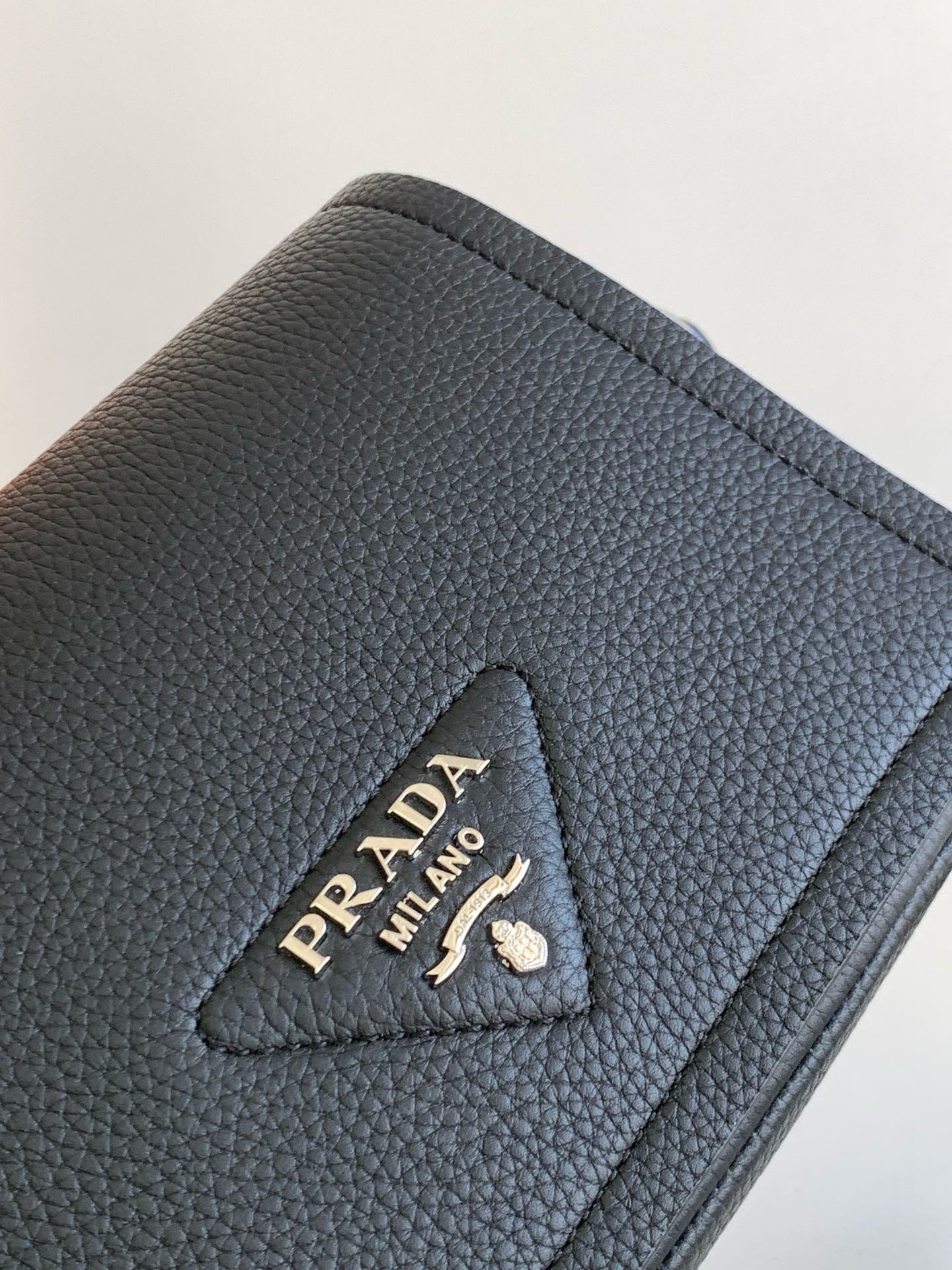 Pra*a flap shoulder bag in black grained leather