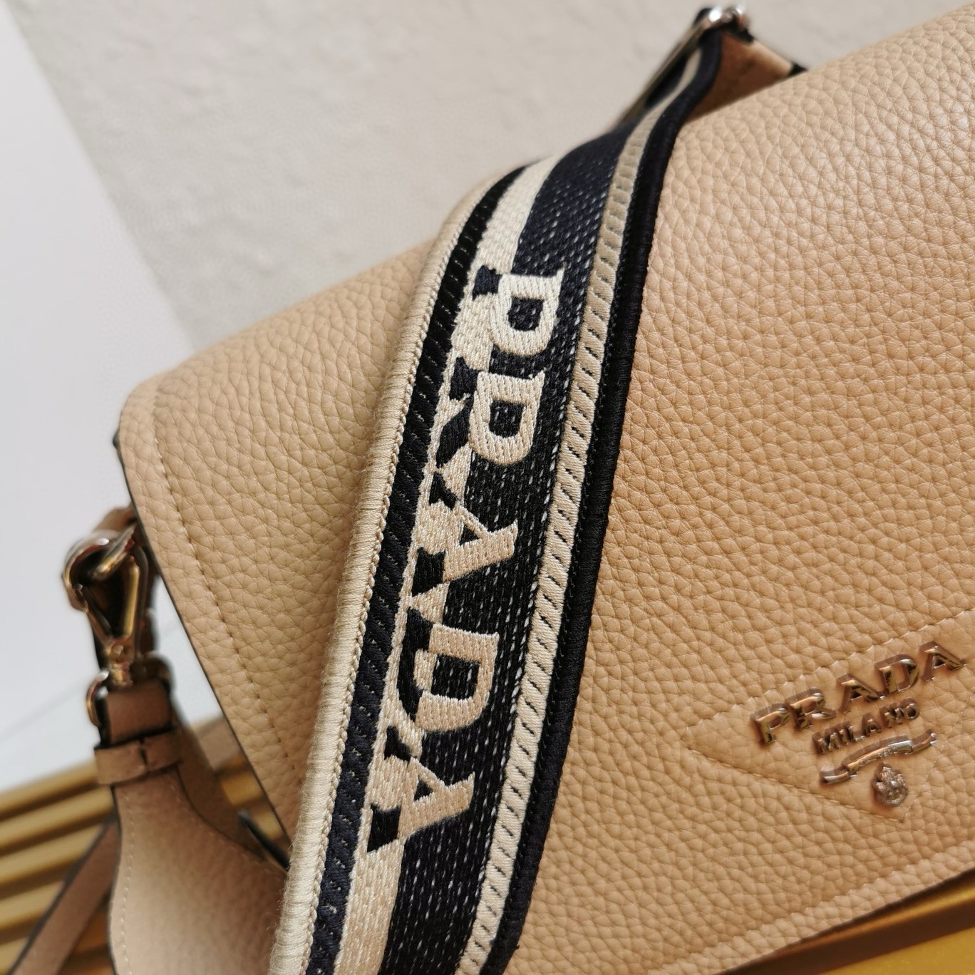 Pra*a flap shoulder bag in sand grained leather
