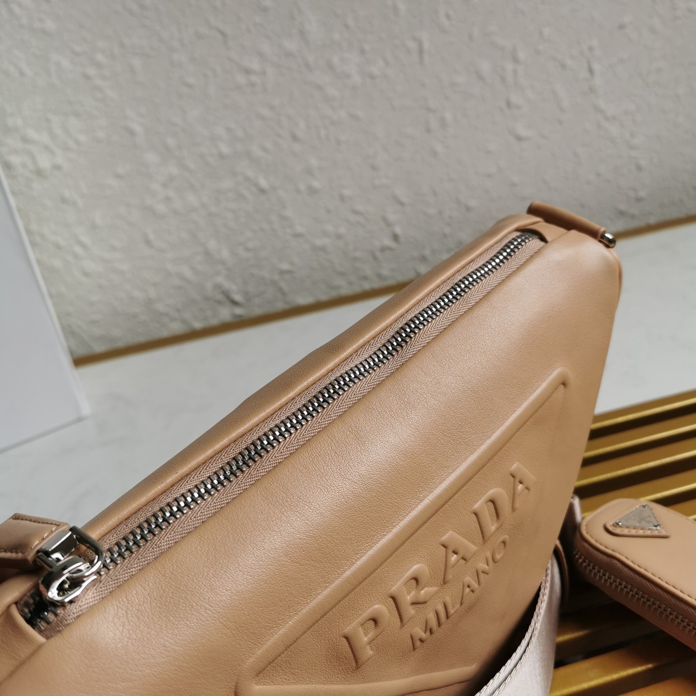 Pra*a triangle shoulder bag in beige leather