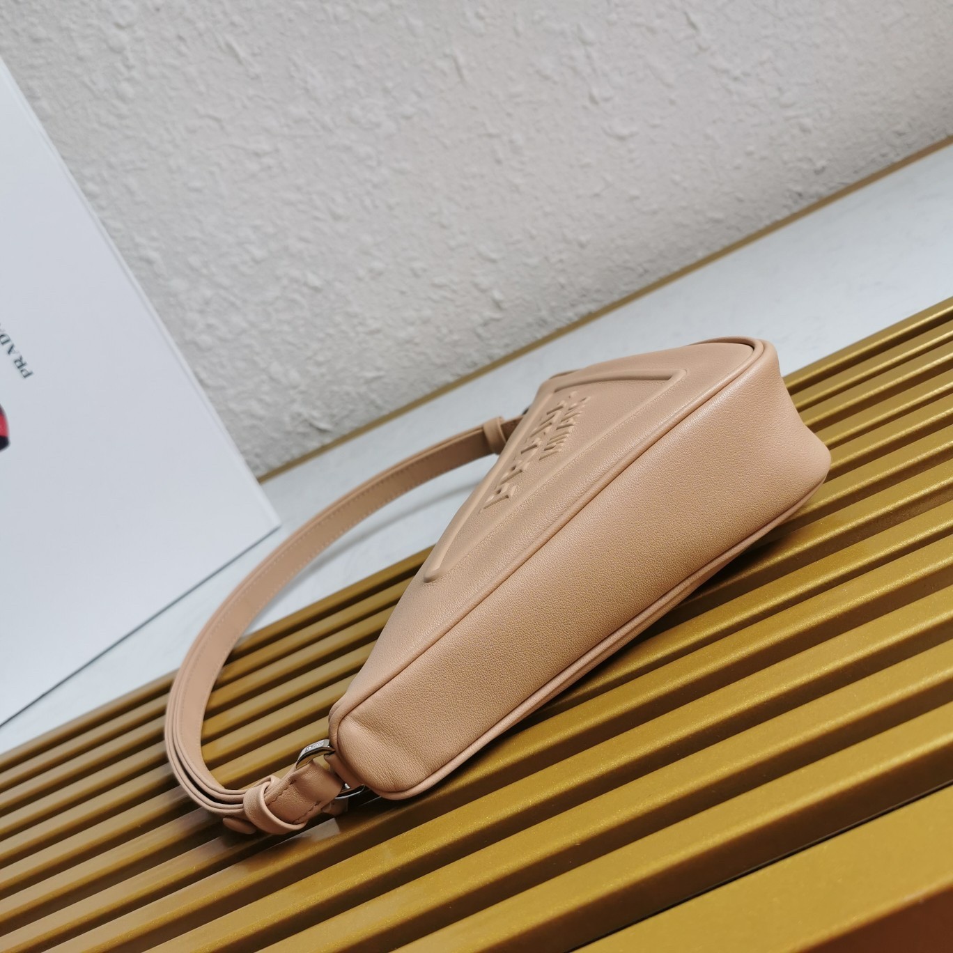 Pra*a triangle pouch bag in beige leather