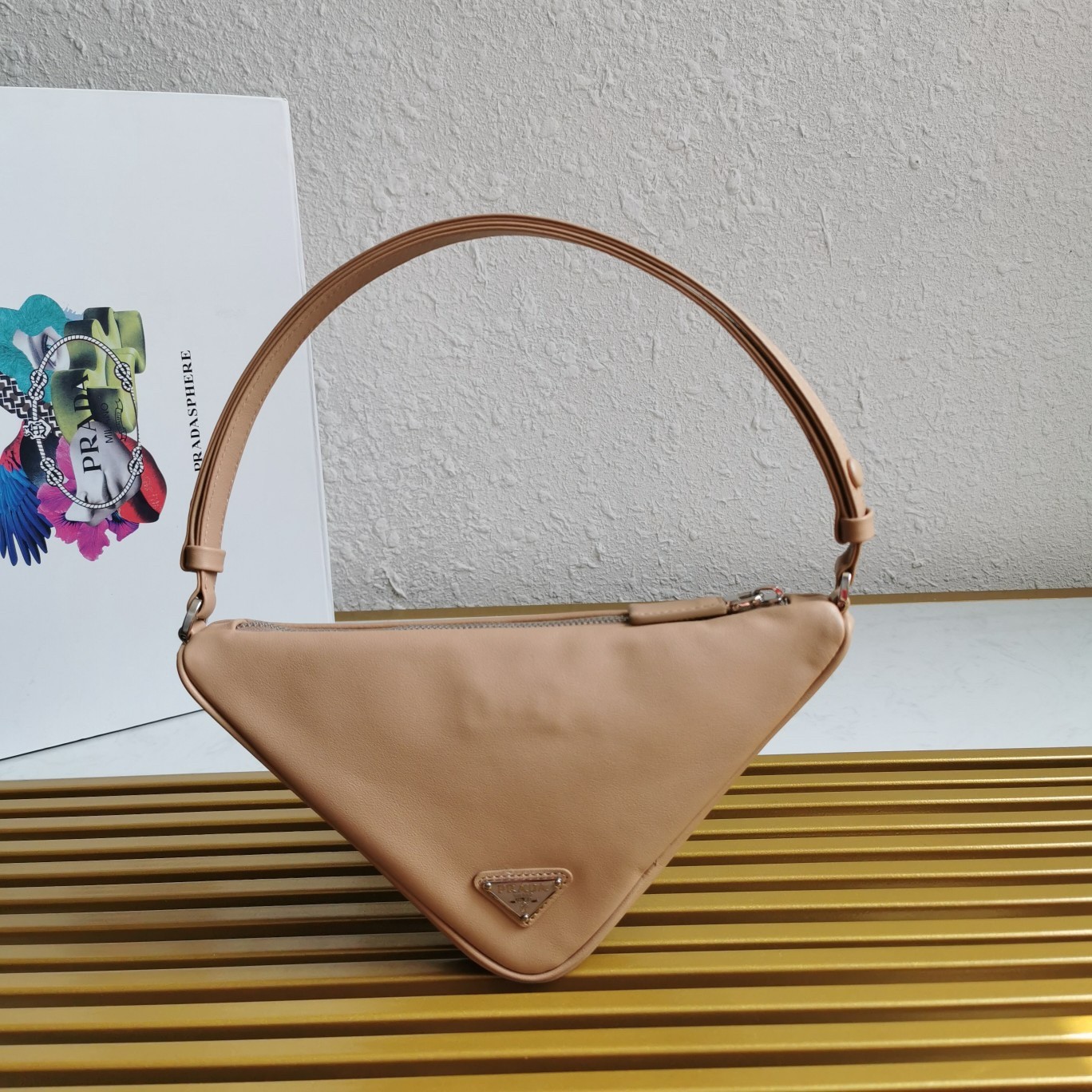 Pra*a triangle pouch bag in beige leather