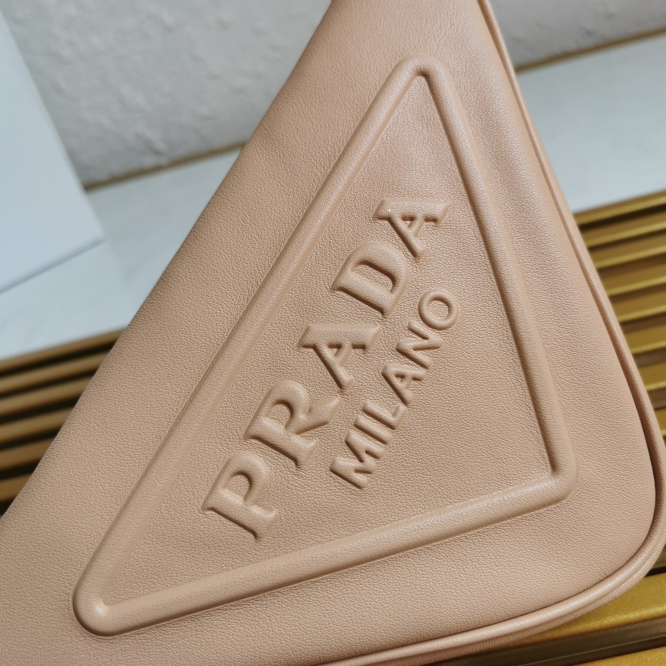 Pra*a triangle pouch bag in beige leather