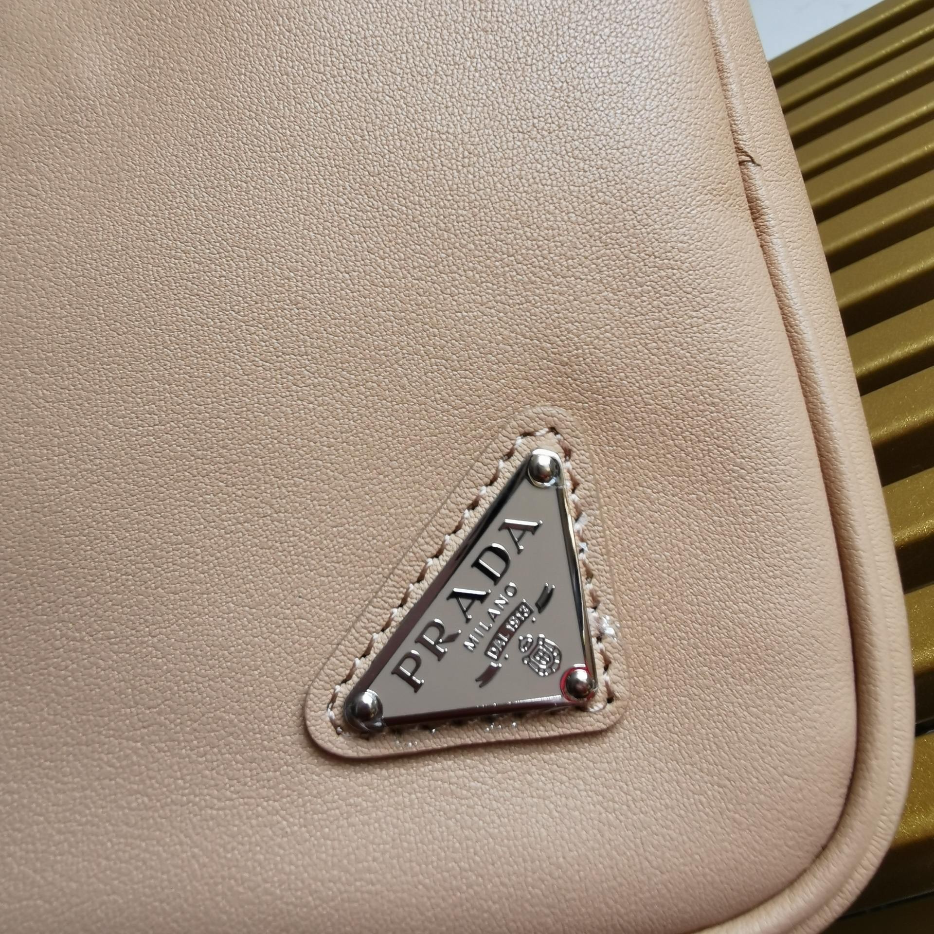 Pra*a triangle pouch bag in beige leather