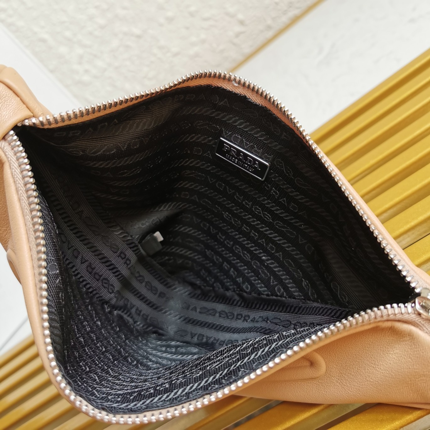 Pra*a triangle pouch bag in beige leather