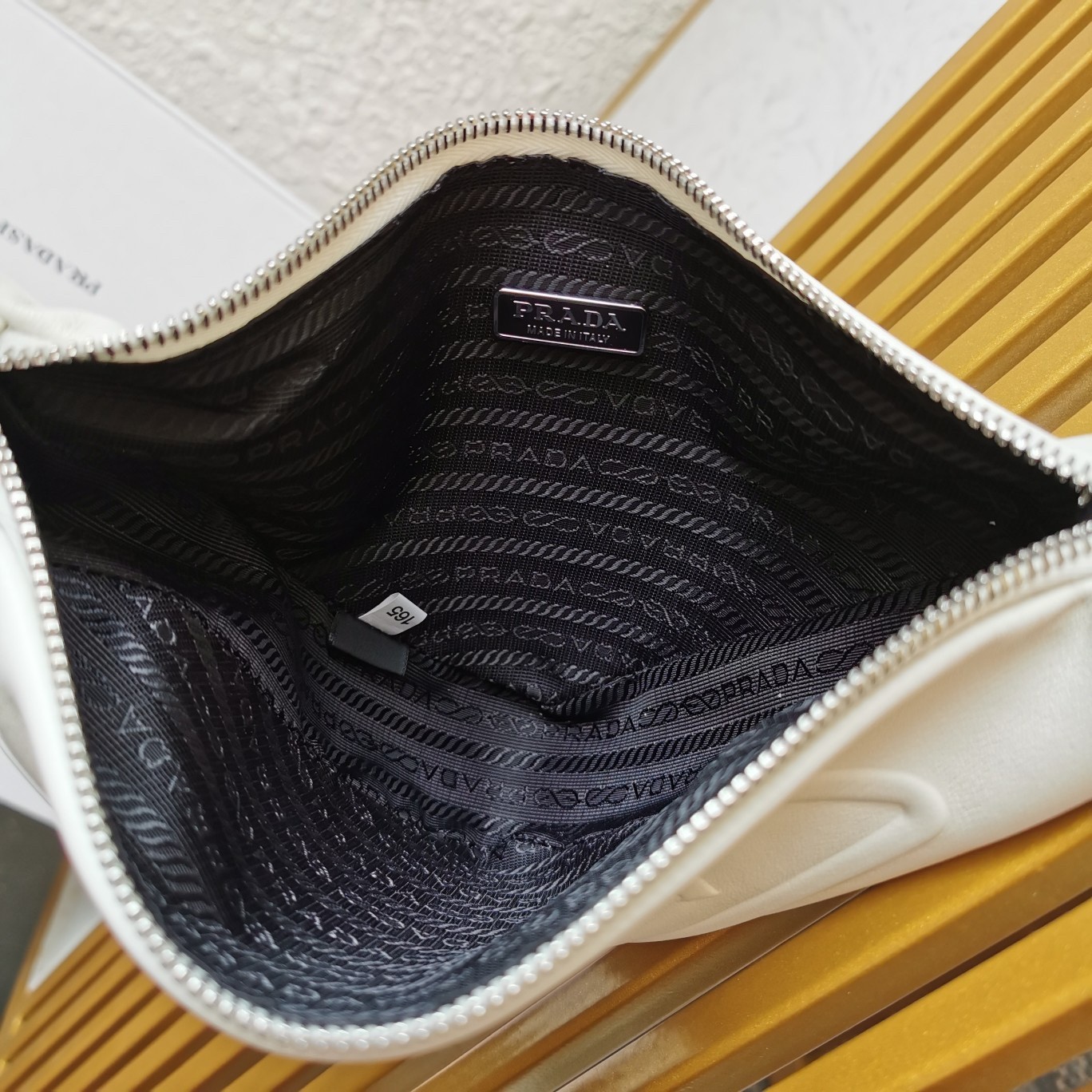 Pra*a triangle pouch bag in white leather