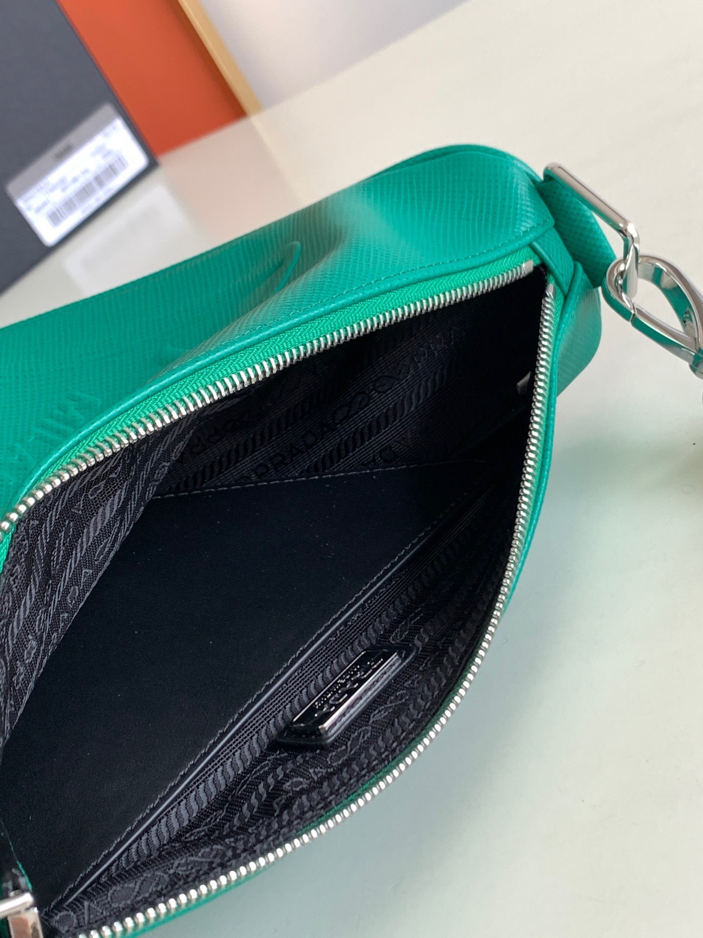 Pra*a triangle shoulder bag in green saffiano calfskin