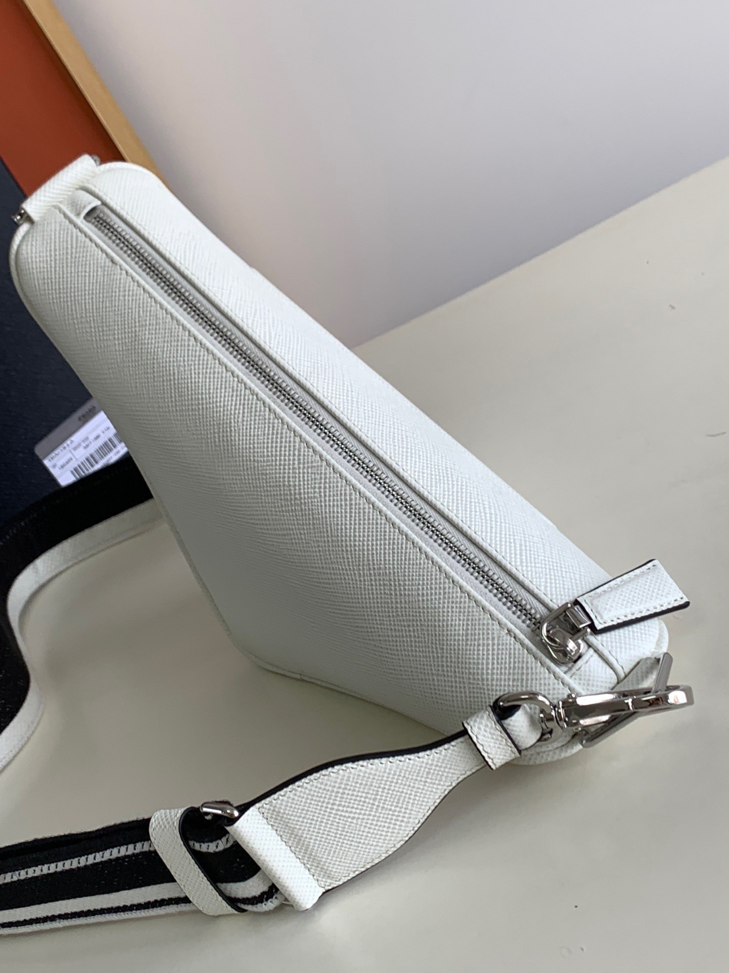 Pra*a triangle shoulder bag in white saffiano calfskin