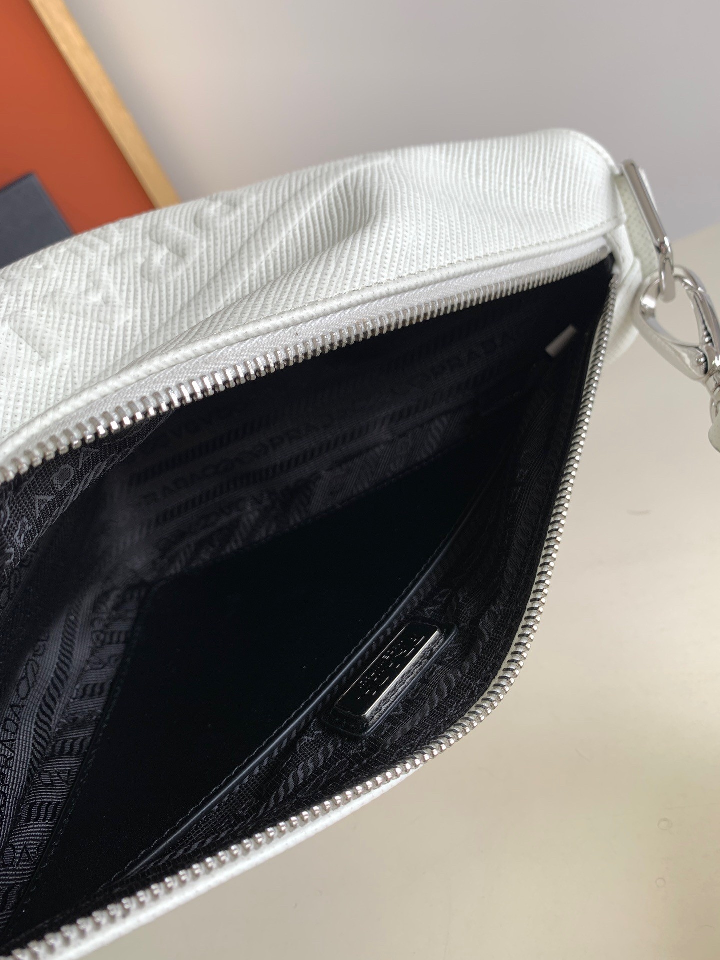 Pra*a triangle shoulder bag in white saffiano calfskin