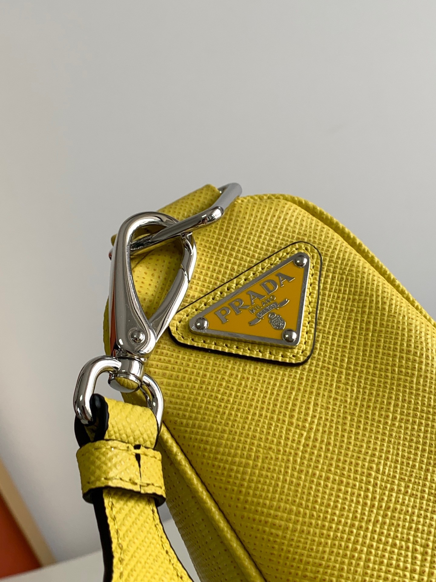 Pra*a triangle shoulder bag in yellow saffiano calfskin