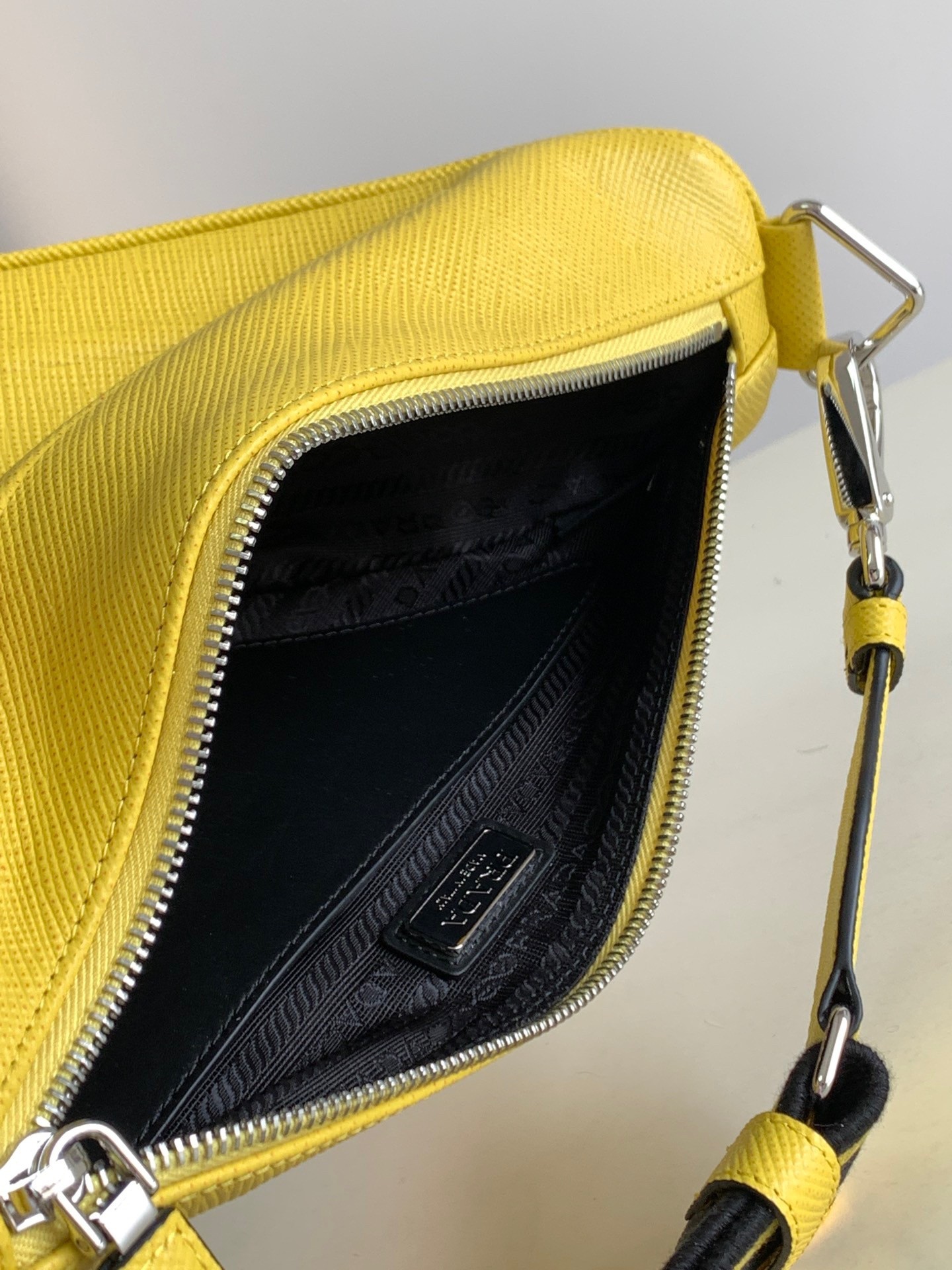 Pra*a triangle shoulder bag in yellow saffiano calfskin