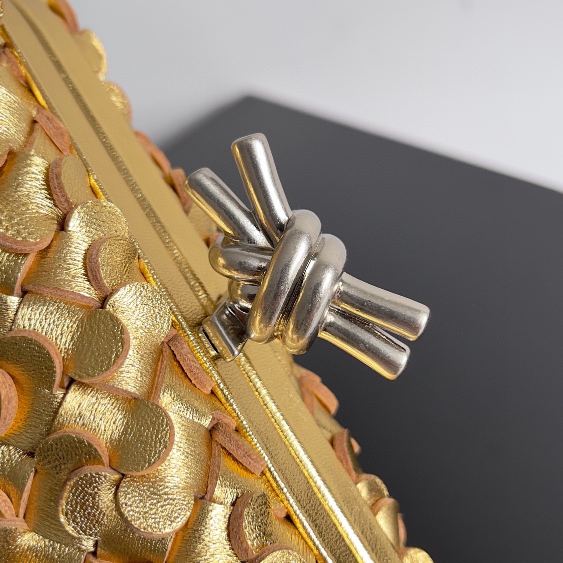 bo*te*ga Ve*ne*ta knot minaudiere clutch in gold sequins laminated leather
