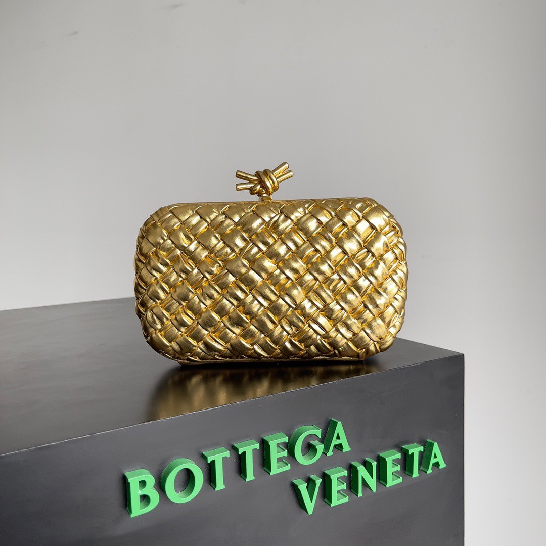 bo*te*ga Ve*ne*ta knot minaudiere clutch in gold intreccio laminated leather