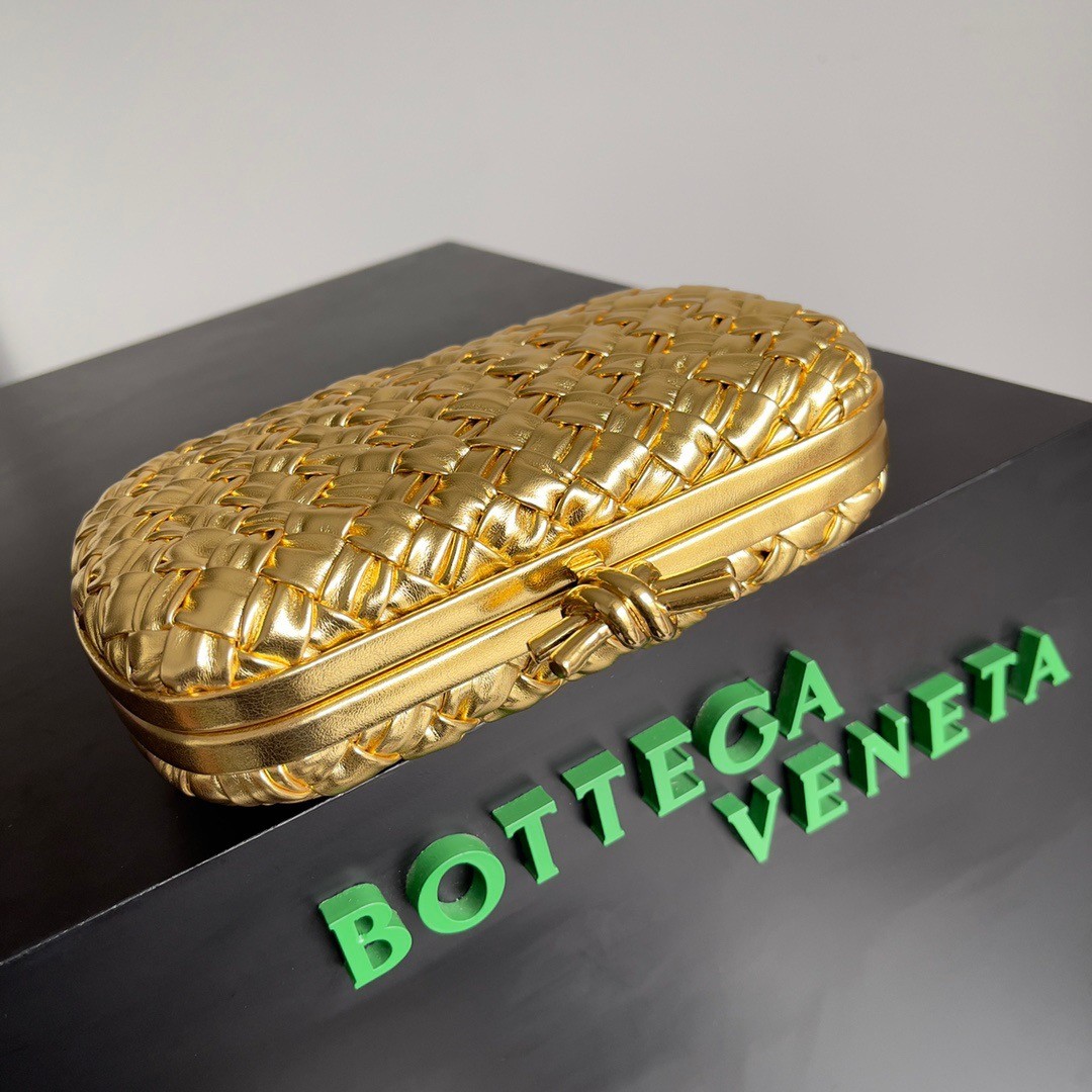 bo*te*ga Ve*ne*ta knot minaudiere clutch in gold intreccio laminated leather