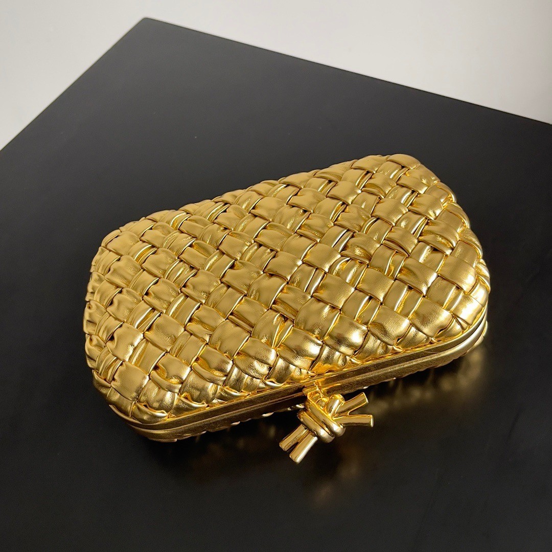 bo*te*ga Ve*ne*ta knot minaudiere clutch in gold intreccio laminated leather