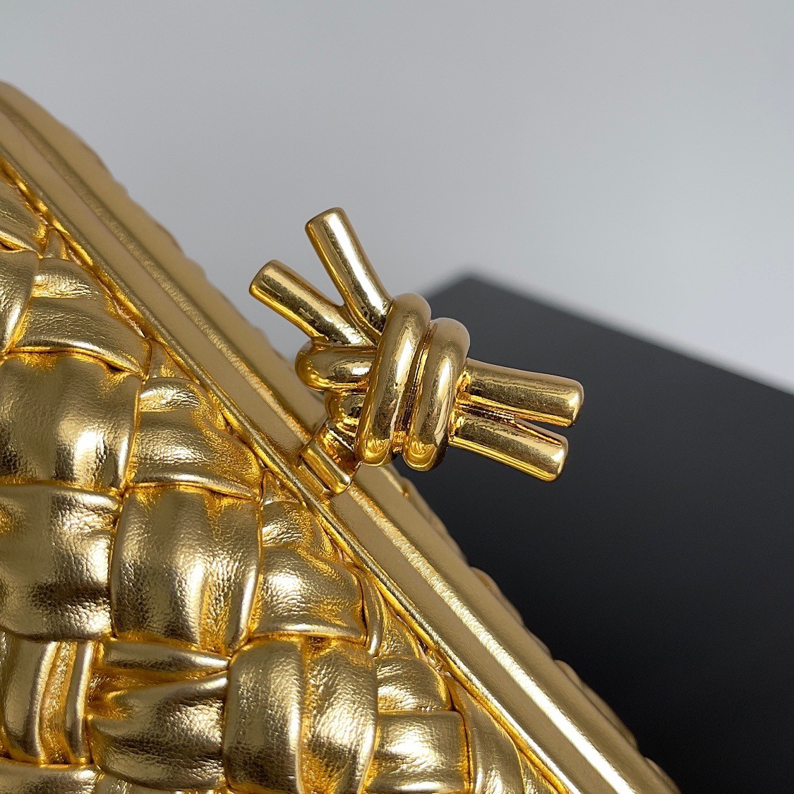 bo*te*ga Ve*ne*ta knot minaudiere clutch in gold intreccio laminated leather