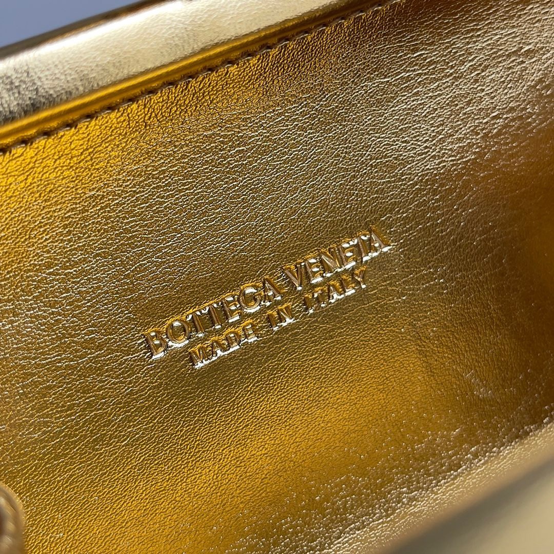 bo*te*ga Ve*ne*ta knot minaudiere clutch in gold intreccio laminated leather