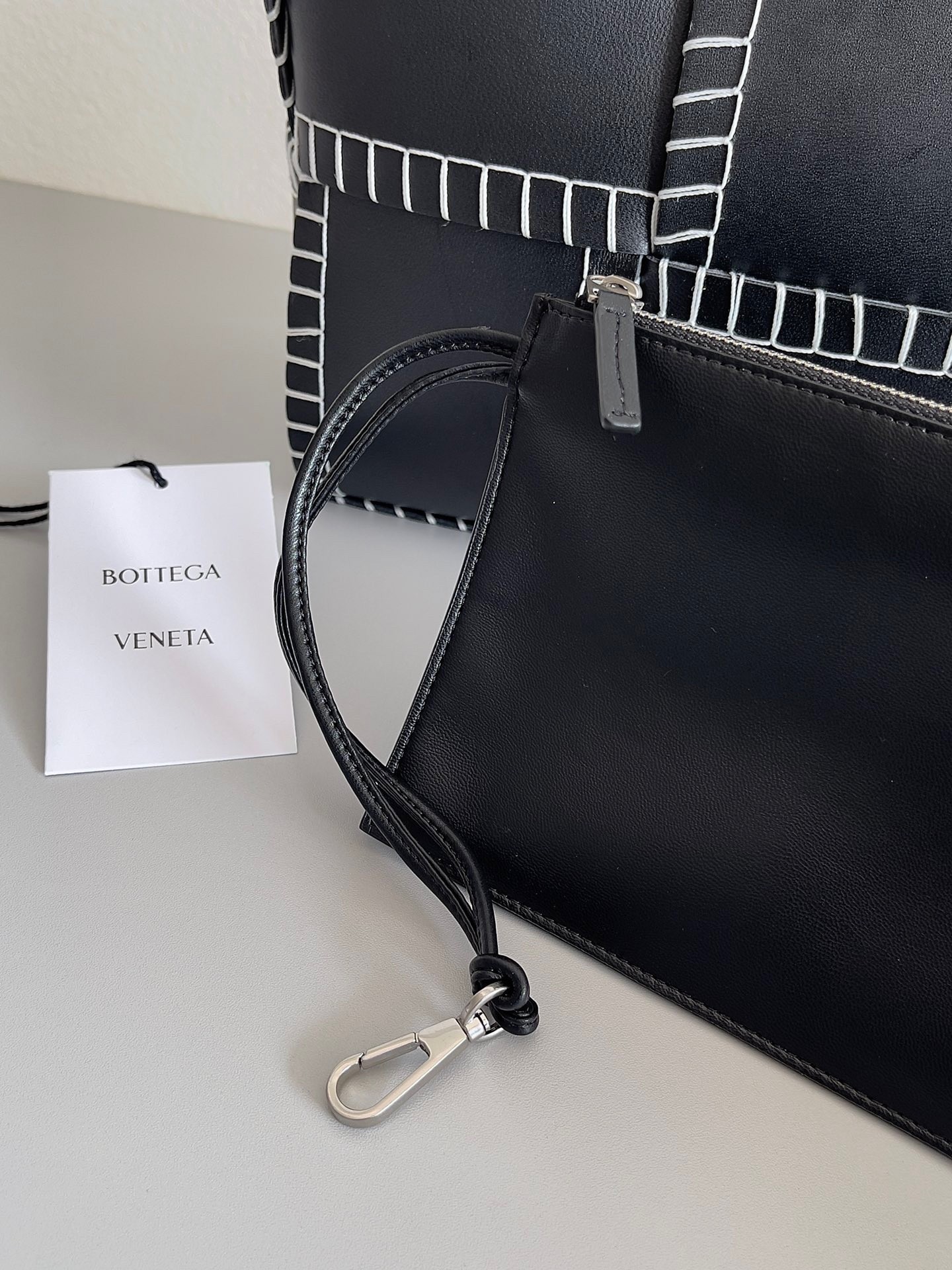 bo*te*ga Ve*ne*ta black arco small tote with white overlock stitching