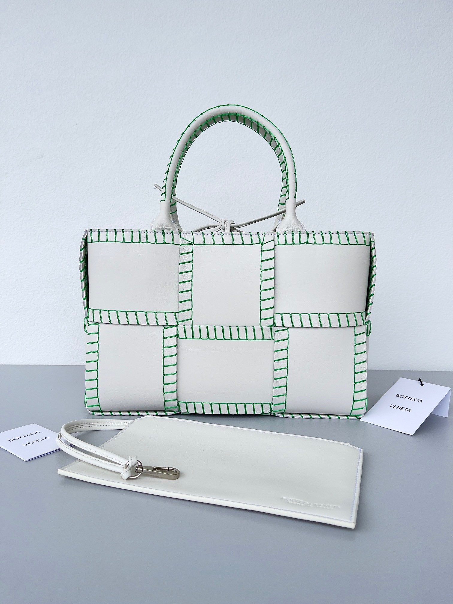 bo*te*ga Ve*ne*ta white arco small tote with green overlock stitching