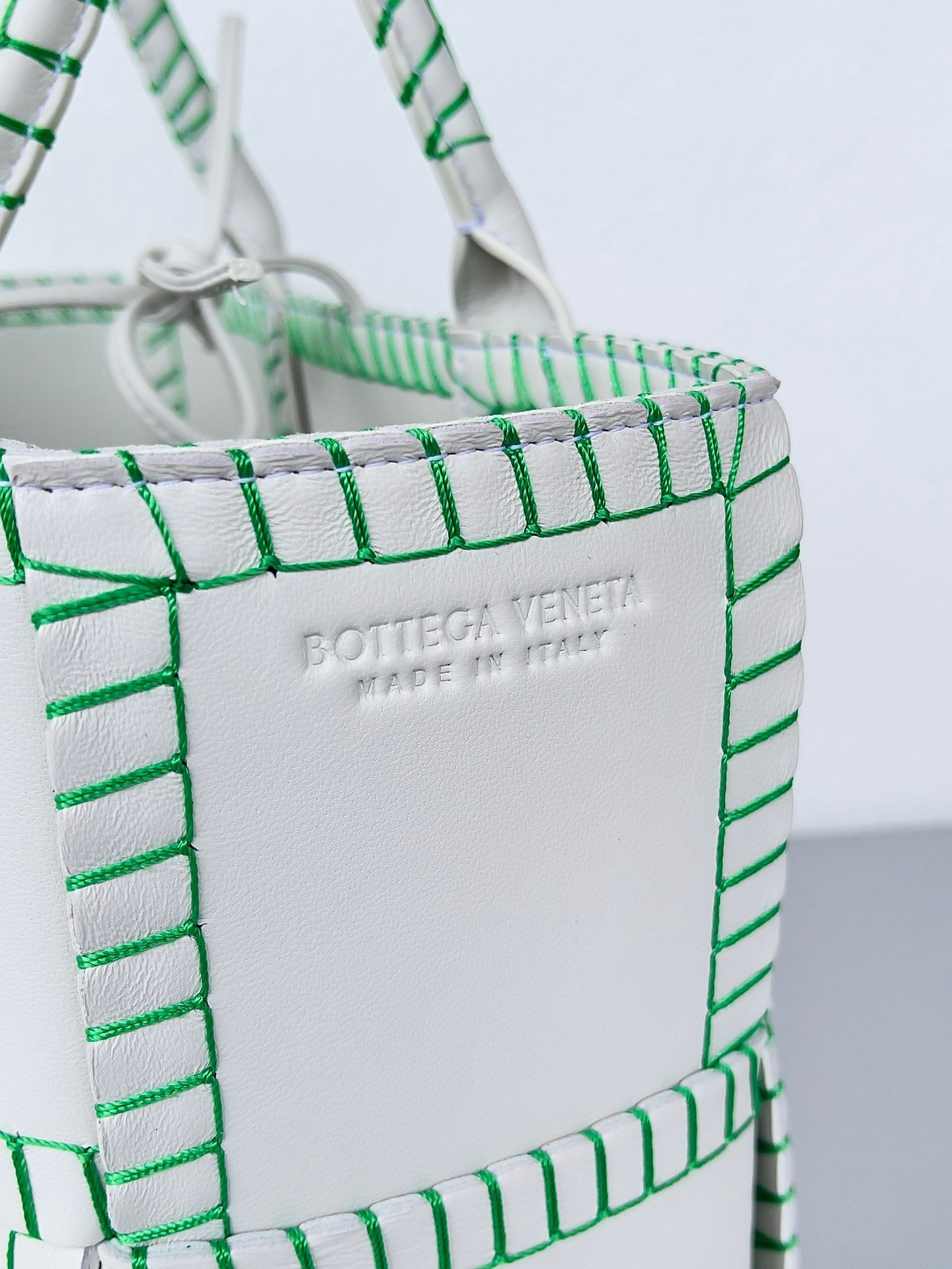 bo*te*ga Ve*ne*ta white arco small tote with green overlock stitching