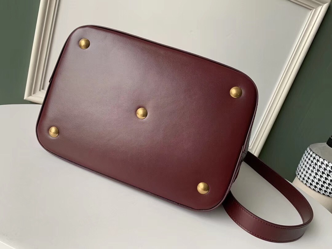 Sa**t Lau*nt monogram all over bucket bag in bordeaux suede